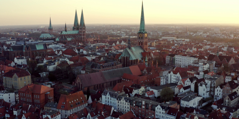 Titel-Video vom LIHO Lübeck Eine Drohnenaufnahme, die die Altstadt von Lübeck, Travemünde mit dem Skandinavienkai und Umgebung aus der Luft zeigt